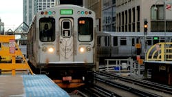 Chicago Transit Authority train approaches a passenger platform after a tight curve. A sign warns of the danger of trespass onto the tracks. Chicago Transit Authority train approaches a passenger platform after a tight curve. A sign warns of the danger of trespass onto the tracks.