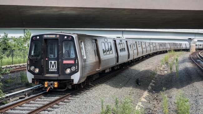 a WMATA orange line train operates down a track under an overpass