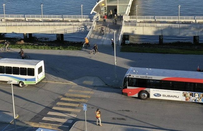 SMCTA branded bus drives down the road near the water front