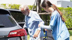 a health aid helps an older man into a car a health aid helps an older man into a car