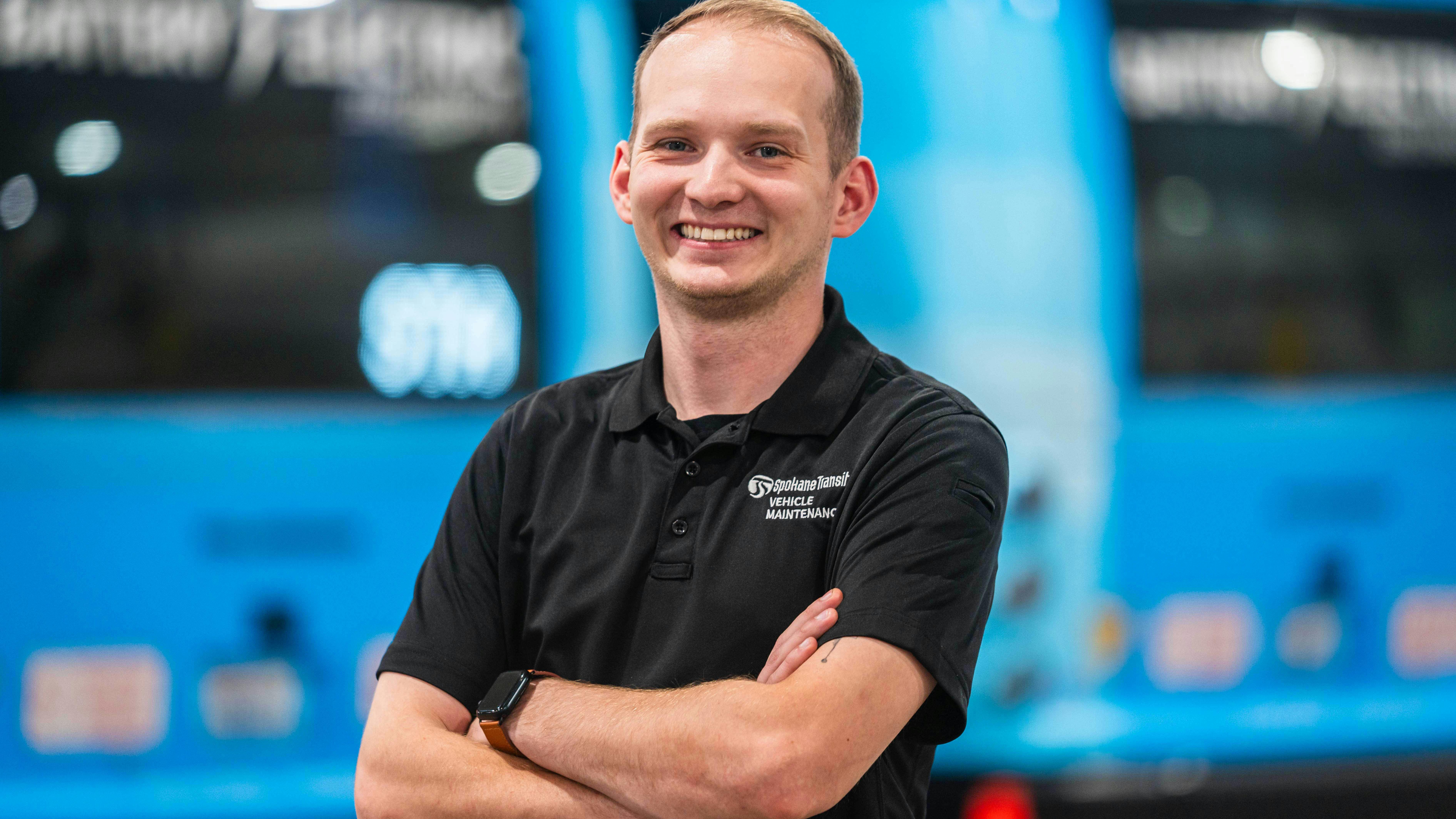Christian bigger headshot in front of a row of parked buses