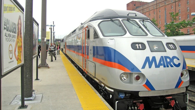 MARC branded diesel locomotive waits at an outside station platform