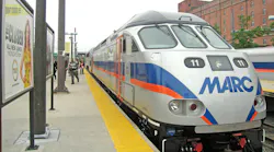 MARC branded diesel locomotive waits at an outside station platform