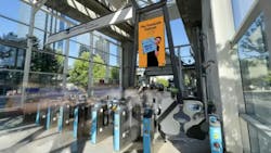 picture of a station entrance that shows the fare gates and a tall signage display picture of a station entrance that shows the fare gates and a tall signage display