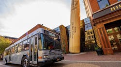 a TARC bus parks in front of the Louisville slugger musuem a TARC bus parks in front of the Louisville slugger musuem