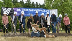 a group of people line up in front of The Vine Highway 99 banner and dig shovels into a pile of dirt. WSU beaver mascot sits in front. a group of people line up in front of The Vine Highway 99 banner and dig shovels into a pile of dirt. WSU beaver mascot sits in front.