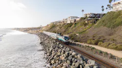 passenger train runs down the coastal corridor next to the ocean