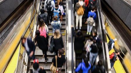 Residents on an escalator in an MTA station.