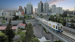 a sound transit train runs on elevated guideway with city skyline in background a sound transit train runs on elevated guideway with city skyline in background
