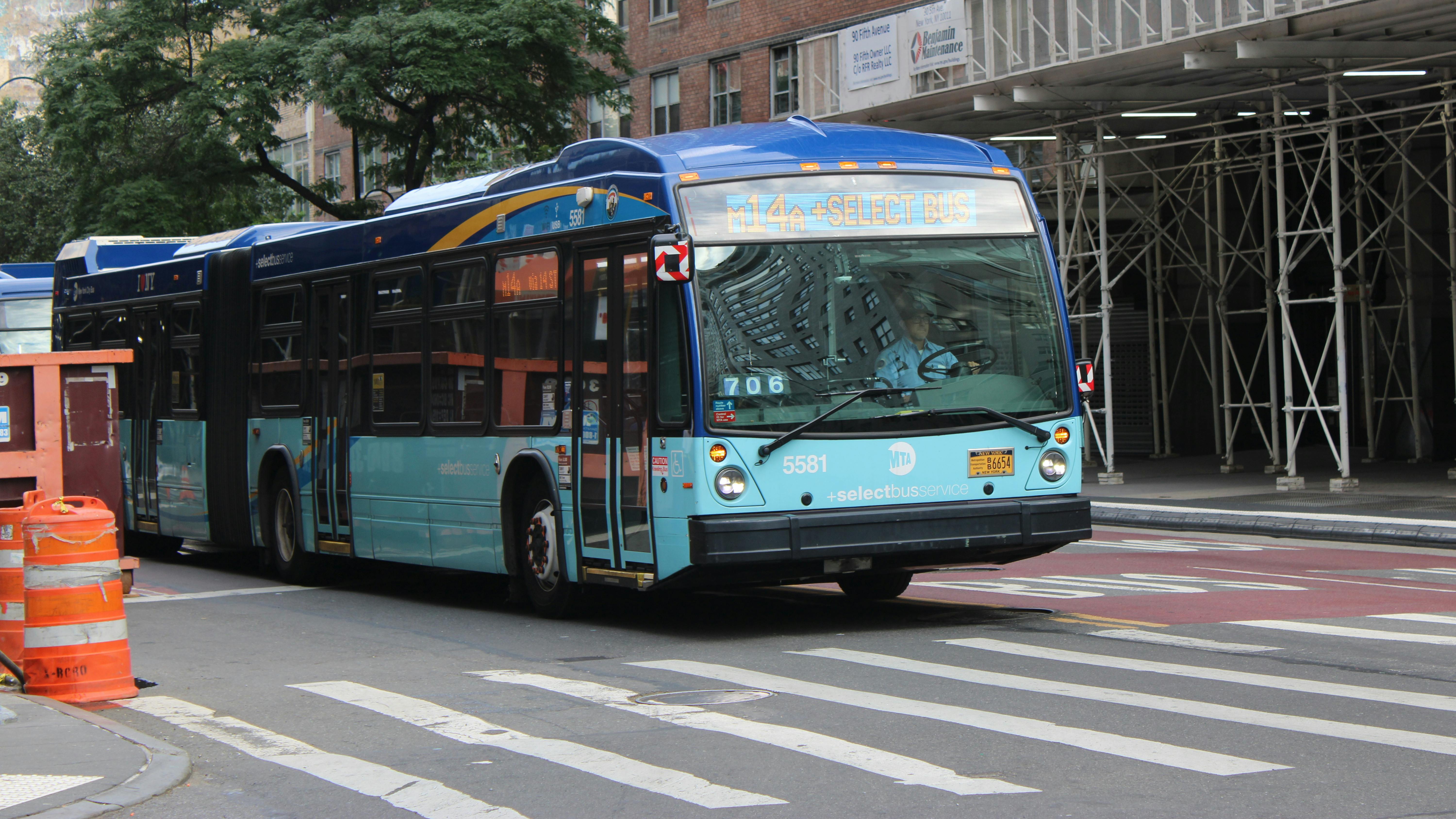 New York City bus travels down a main street in downtown New York City