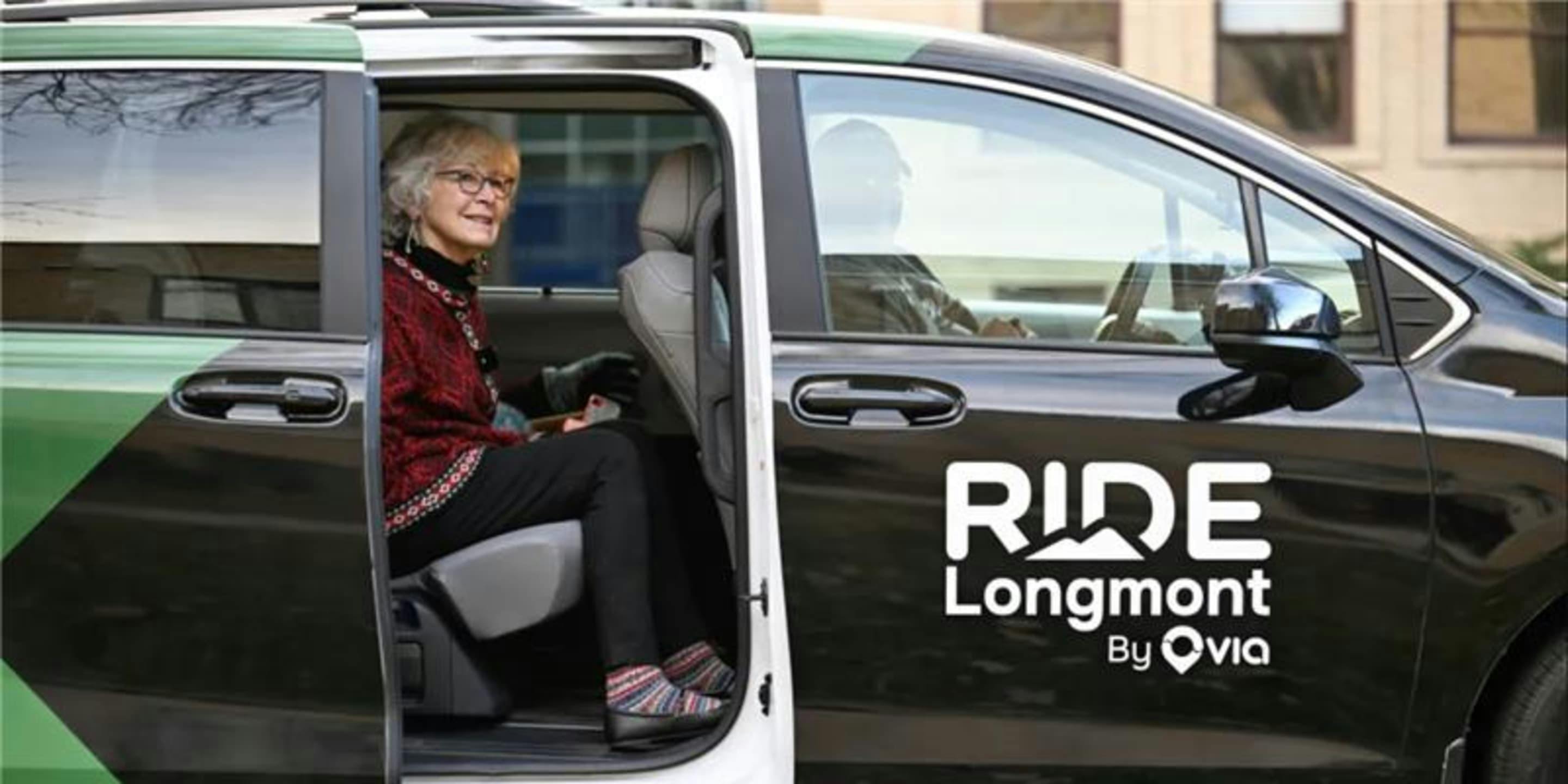 Passenger sits in the rear seat of a RIDE Longmont transit van.