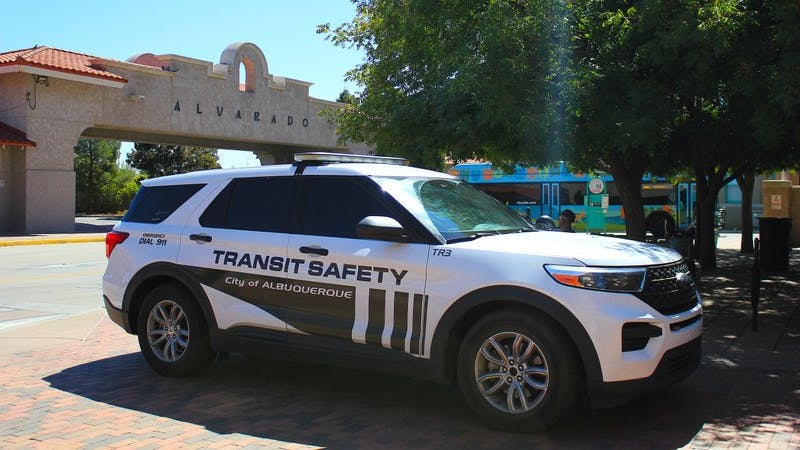 A Transit Safety enforcement vehicle sits parked near a bus stop.