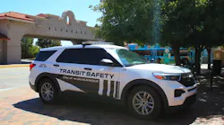 A Transit Safety enforcement vehicle sits parked near a bus stop.