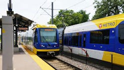 Two Blue Line light rail trains sit at a station. Two Blue Line light rail trains sit at a station.