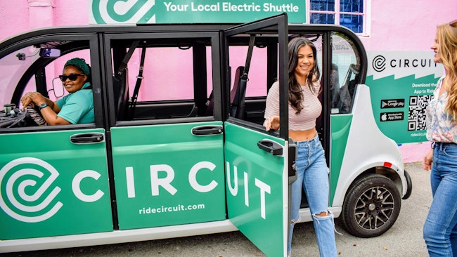 A woman exits a Circuit electric shuttle.