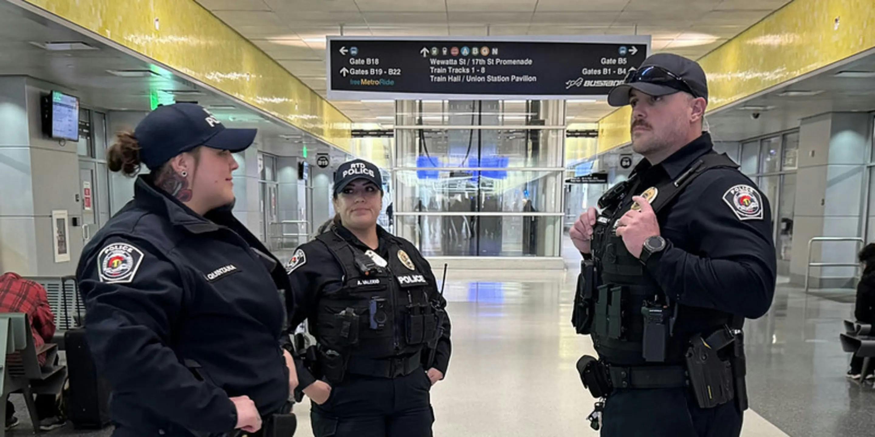 Three RTD-PD officers stand together in a transit station.
