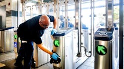 A man finishes the installation of a fare gate at a BART station. A man finishes the installation of a fare gate at a BART station.