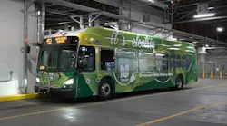 An electric NJ Transit bus sits parked with its lights on bearing 'it's electric' livery.