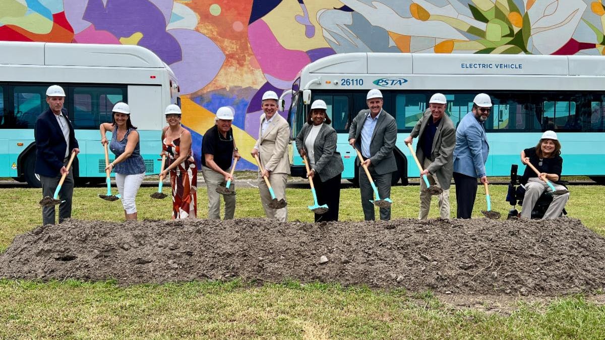 Members of the converging agencies all hold shovels that have just taken the first scoop out of the dirt at the site of what will be the new transit center.