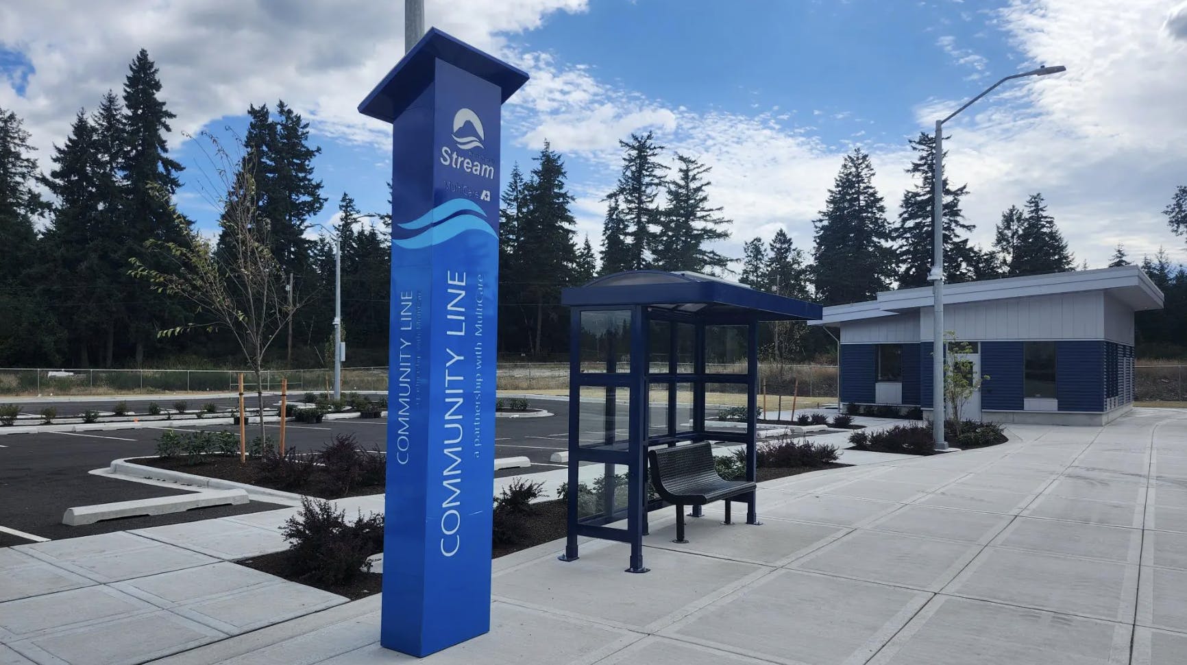 sign post that says community line with bus shelter and bench in background