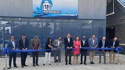 government officials stand before the new transit center, cutting the inaugural ribbon. government officials stand before the new transit center, cutting the inaugural ribbon.