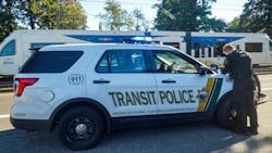 A transit police officer works over the hood of their cruiser. A transit police officer works over the hood of their cruiser.
