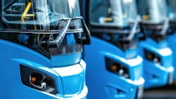 Buses sit in a line next to each other. Buses sit in a line next to each other.