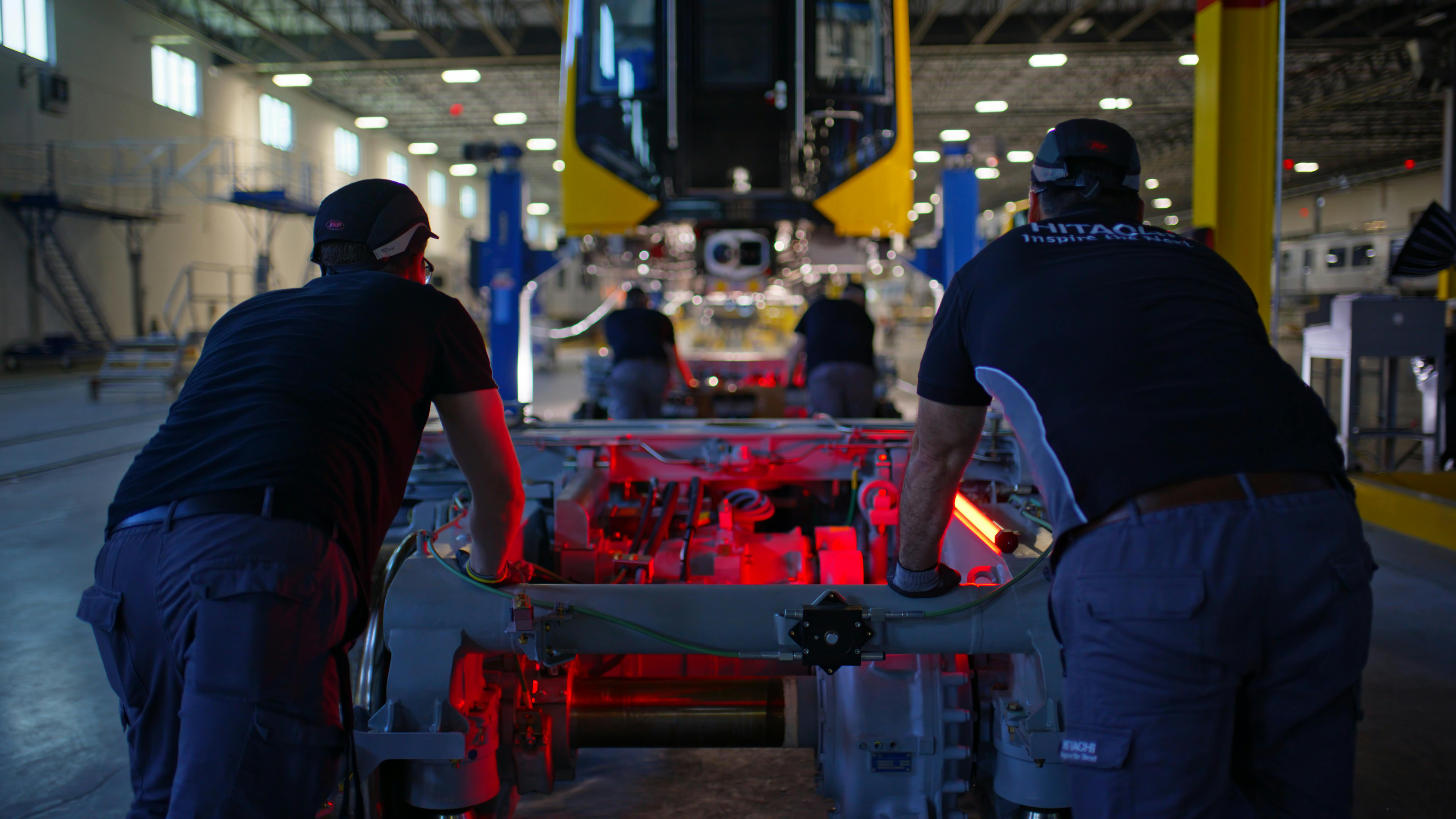 Two Hitachi employees work on the production line.
