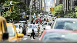 People cross a busy New York City street.