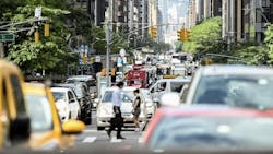 People cross a busy New York City street. People cross a busy New York City street.