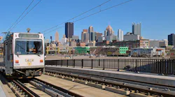A red line train moves down the track.