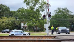 A North Carolina Police Department vehicle and officers at a railroad crossing. A North Carolina Police Department vehicle and officers at a railroad crossing.