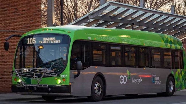 A GoTriangle electric bus sits at a bus stop.