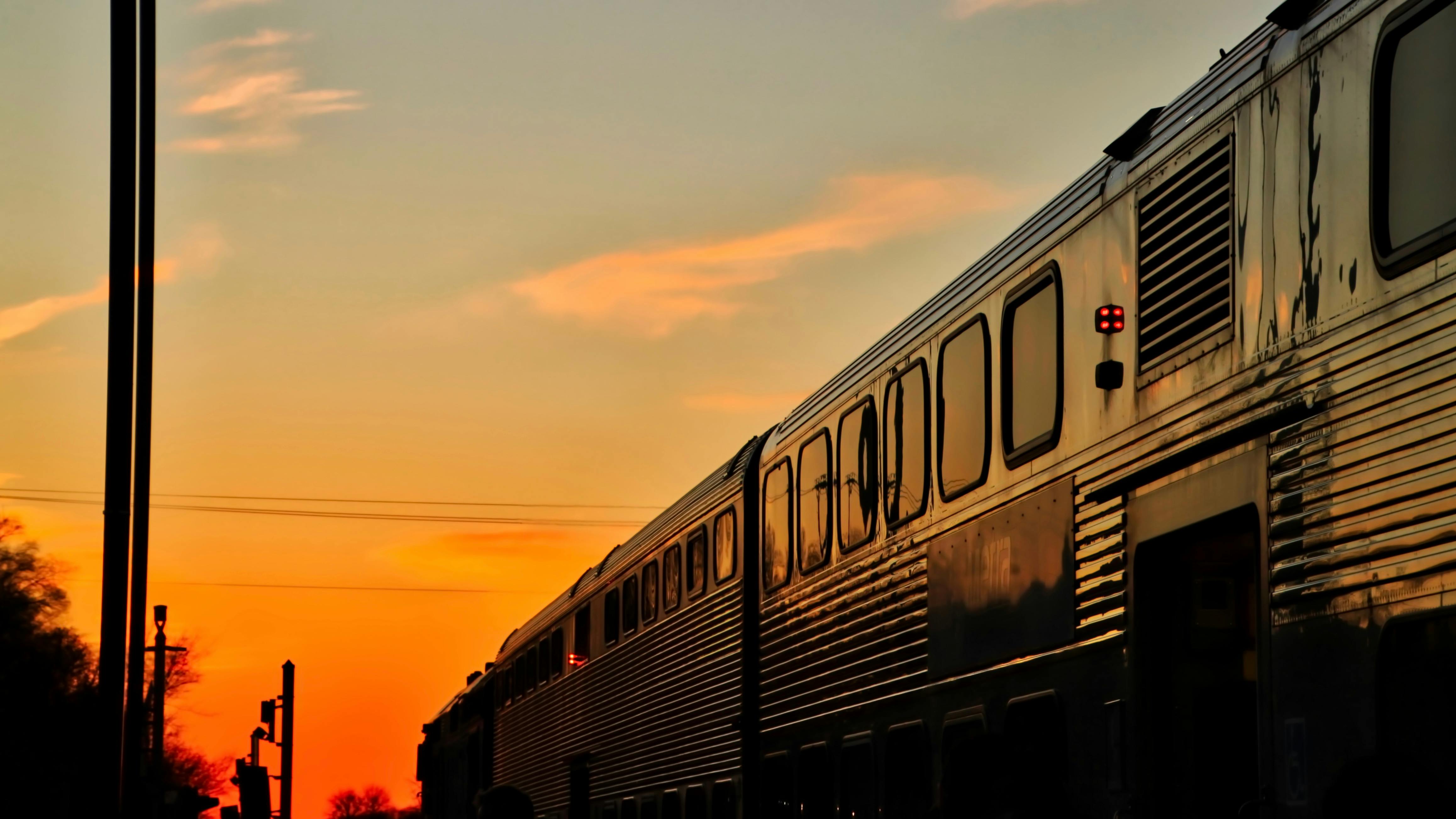 A Metra train travels at sunset.