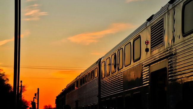 A Metra train travels at sunset.