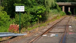 at-grade empty railroad crossing with sign that says no trespassing active railroad next to it at-grade empty railroad crossing with sign that says no trespassing active railroad next to it