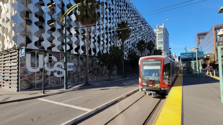 A light-rail car moves down the street.