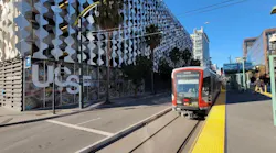 A light-rail car moves down the street.