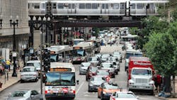 CTA buses drive down the street through heavy traffic. CTA buses drive down the street through heavy traffic.