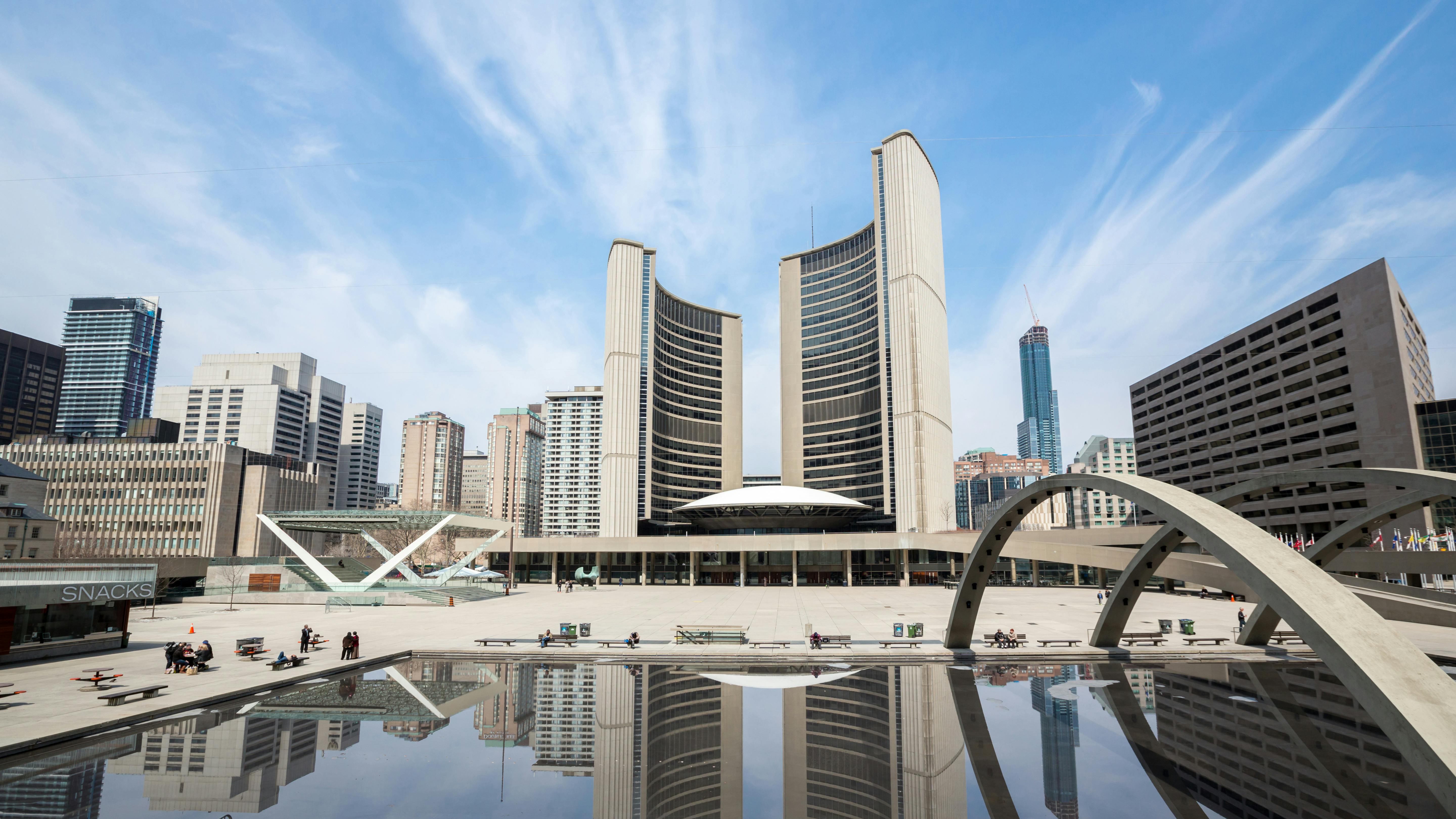 The image features a wide shot of the Toronto City Hall.