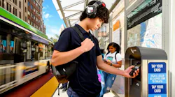 A passenger taps their phone to a Clipper vending machine.