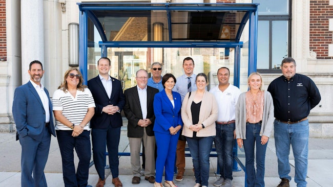 City leaders stand posed in front of the new bus shelter.