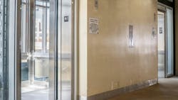 A bank of elevators host open doors. A bank of elevators host open doors.