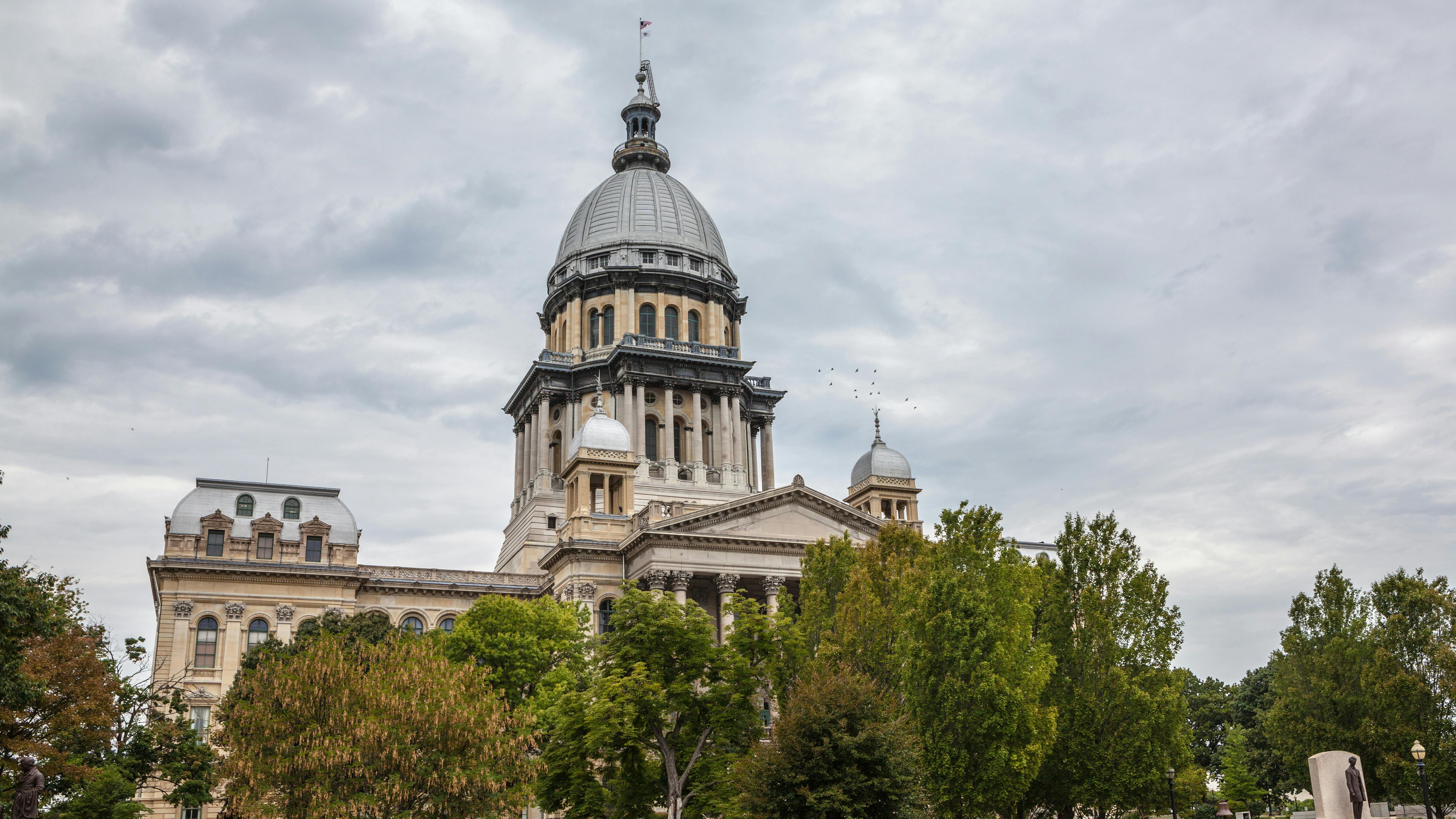 The image shows a drone shot of the Illinois State House in Springfield, IL.