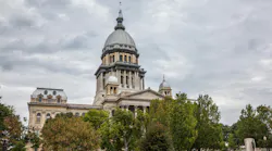 The image shows a drone shot of the Illinois State House in Springfield, IL.