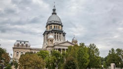 The image shows a drone shot of the Illinois State House in Springfield, IL. The image shows a drone shot of the Illinois State House in Springfield, IL.