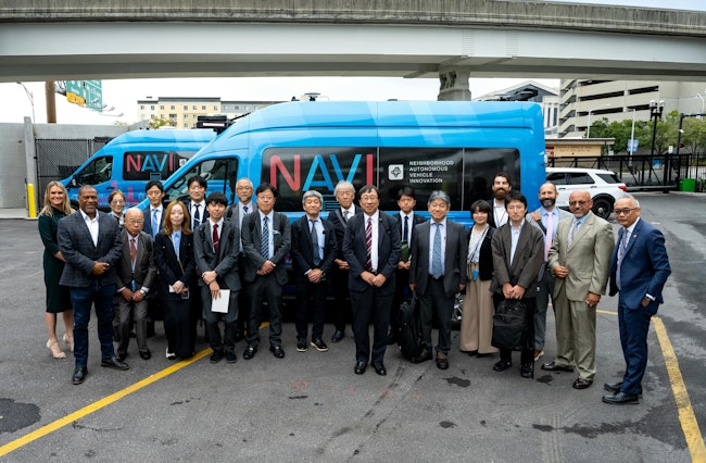 The image displays a group shot of the delegation with local leaders.