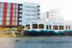 The image shows a Sound Transit train running down the track. The image shows a Sound Transit train running down the track.