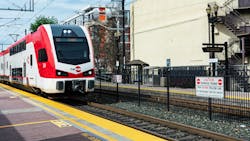Double-decker Caltrain electric train approaches a station. Double-decker Caltrain electric train approaches a station.