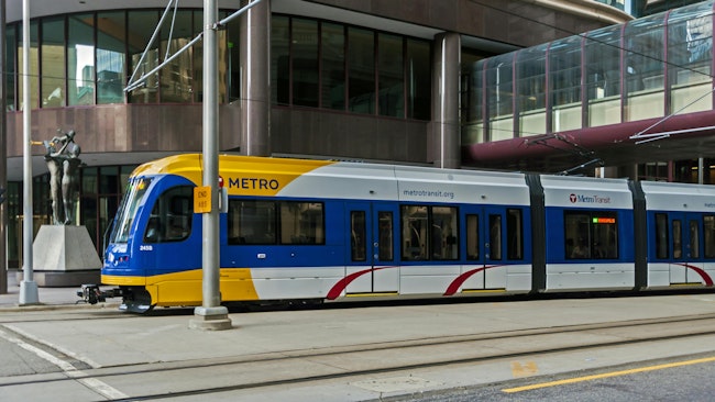 The image shows a Metro Transit light-rail train roll down the track.